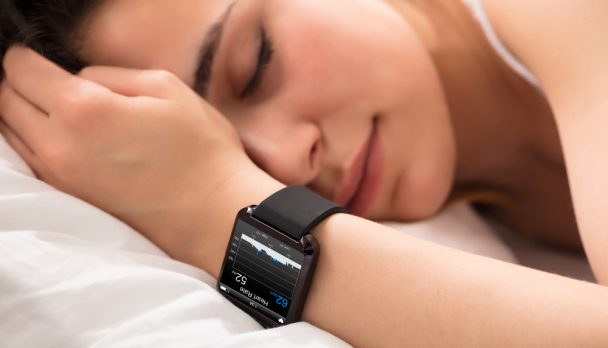 Woman,Sleeping,On,Bed,With,Smart,Watch,Showing,Heartbeat,Monitor